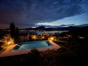 una piscina con vistas a la ciudad por la noche en Bella Vista am Gardasee - Albisano, en Albisano