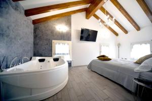 een badkamer met een groot bad in een slaapkamer bij La casa del gufo - B&B la Casa di Graz in Reggio Emilia