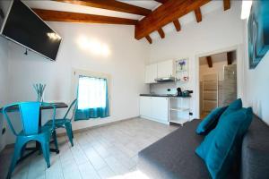 een woonkamer met een bank en een tafel en een keuken bij La casa del gufo - B&B la Casa di Graz in Reggio Emilia