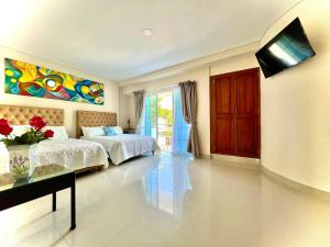 1 dormitorio con 2 camas y TV en la pared en Charme 64 Hotel Boutique Aeropuerto, en Cartagena de Indias
