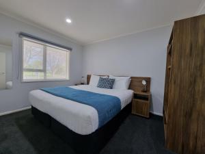 Antonio Mews Motel في ستراتفورد: غرفة نوم بسرير كبير ونافذة