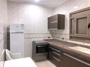 a small kitchen with a refrigerator and a sink at La Perle de L'ocean N03 là ou' le confort rencontre le luxe face à l'atlantique in Akhfennirr