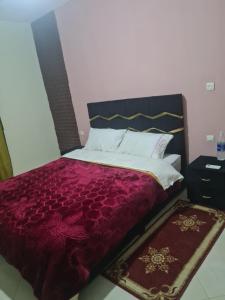 - une chambre avec un grand lit et une couette violette dans l'établissement Auberge belle vue itto A Station de sevice ZIZ, à Aït nʼTaleb Akka