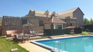 a house with a swimming pool and a gazebo at Auberge belle vue itto A Station de sevice ZIZ in Aït nʼTaleb Akka