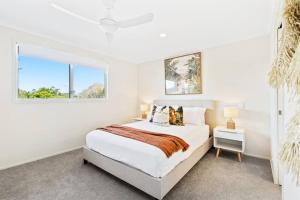 a white bedroom with a bed and a window at Stunning Waterfront Oasis in Gold Coast +18 photos