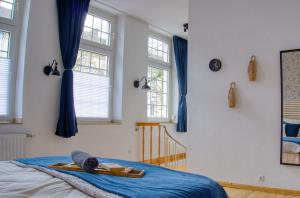 Schlafzimmer mit blauen Vorhängen und einem Bett mit blauer Bettwäsche in der Unterkunft No.1 by 21Apartments in Krefeld