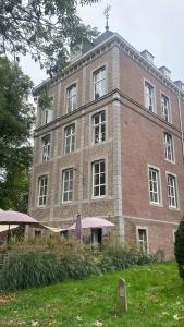 un gran edificio de ladrillo con sombrillas delante en SEPHS Hotel, en Sittard