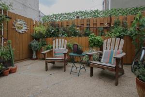 a patio with two chairs and a table in front of a fence at Artsy Hidden Gem ll -Free Parking --- in Philadelphia +8 photos