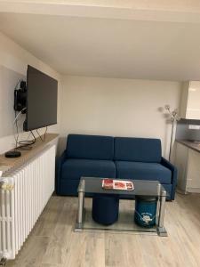 sala de estar con sofá azul y mesa en Appartement neuf 1 à 6 personnes dans maison individuelle en Haguenau