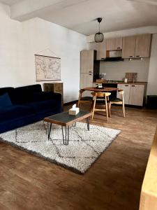 een woonkamer met een blauwe bank en een tafel bij Appartement Centre ville Le blanc in Le Blanc