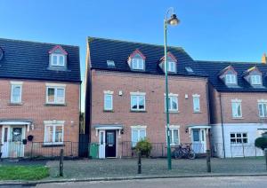 um grupo de casas de tijolos com uma luz de rua em Eagle Way Apartment em Peterborough