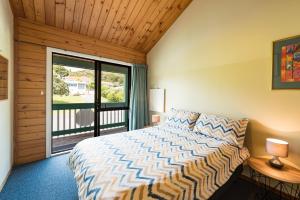 a bedroom with a bed and a large window at Bay of Islands Lodge in Paihia