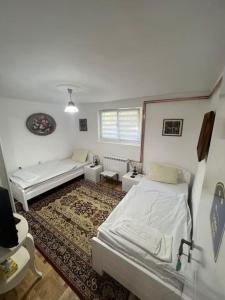ein Zimmer mit 2 Betten und einem Sofa darin in der Unterkunft Smeštaj Milinković in Kovanluk