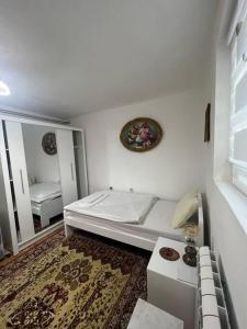 a white room with a bed and a mirror at Apartment Milinković 2 in Kovanluk