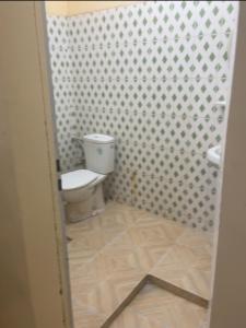a small bathroom with a toilet and a shower at Residence Mouna in Nouadhibou