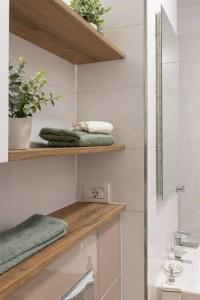 a bathroom with a sink and shelves with towels at Joy City Stay Nord One N2-66 in Timişoara