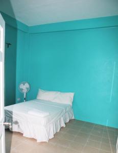a bedroom with a blue wall and a bed at Paradise Apartment in Castries