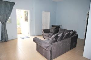 a living room with a couch and a chair at Paradise Apartment in Castries