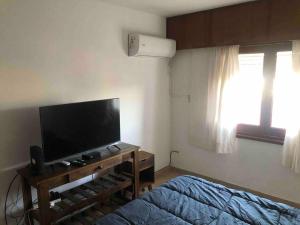 a bedroom with a bed and a flat screen tv at Departamento muy amplio, 3 habitaciones, 2 baños! in Junín