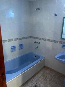 La salle de bains est pourvue d'une baignoire bleue et d'un lavabo. dans l'établissement Departamento muy amplio, 3 habitaciones, 2 baños!, à Junín