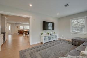 a living room with a couch and a tv on a wall at Sleek and Modern Cape Cod Home 2 Mi to Beaches! in Hyannis