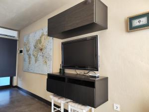 sala de estar con TV de pantalla plana en la pared en Casa Natalia en Tías