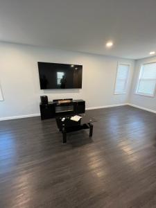 a living room with a flat screen tv and a coffee table at Private Studio in Providence