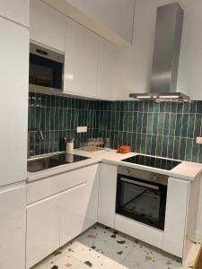 eine Küche mit weißen Schränken und einem Waschbecken in der Unterkunft Nîmes Appartement de charme Terracotta in Nîmes