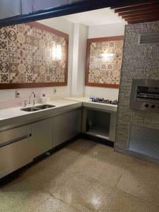 a kitchen with a sink and a stove at Cobertura incrível, com jacuzzi e churrasqueira. in Belo Horizonte