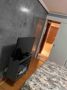 a bedroom with a bed and a television on a dresser at Cobertura incrível, com jacuzzi e churrasqueira. in Belo Horizonte