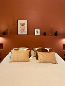 - une chambre avec un grand lit blanc et 2 oreillers dans l'établissement Nîmes Appartement de charme Terracotta, à Nîmes