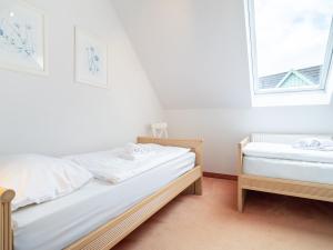 two beds in a room with two windows at Ferienhaussiedlung Strandperlen Sanddornhof 4a (Typ IX) in Wustrow