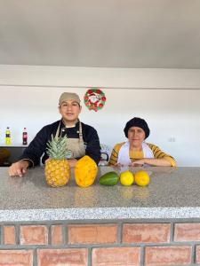 a man and a woman sitting on a counter with fruit at Hotel Los Pajonales in Huaraz