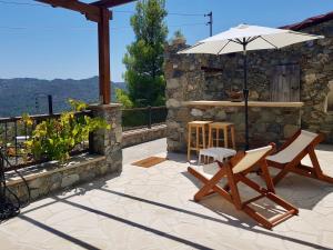een patio met 2 stoelen en een parasol bij Traditional House with Mountain View - Dierona Village in Dierona