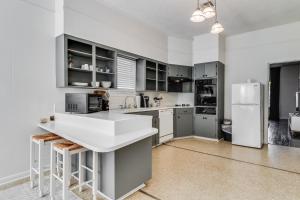 cocina con armarios grises y nevera blanca en Jefferson Rental Room 1, en Lafayette