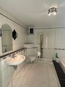 La salle de bains blanche est pourvue d'un lavabo et de toilettes. dans l'établissement Gemütliche Ferienwohnung in Wolfhagen mit Terrasse, à Wolfhagen