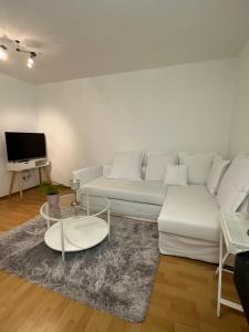 - un salon avec un canapé blanc et une table dans l'établissement Gemütliche Ferienwohnung in Wolfhagen mit Terrasse, à Wolfhagen