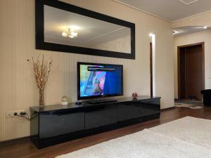 a living room with a flat screen tv on a cabinet at One-Bedroom Apartment in the center in Dnipro