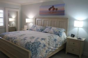 a bedroom with a bed with a blue and white comforter at Captiva Bayside Villas 1 Bedroom 2 Bath - sleep 4 in Captiva