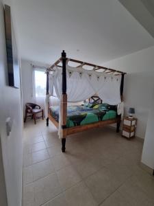 a bedroom with a bed with a canopy at Villa Les Oursins 130 m² - Piscine privée in Les Trois-Îlets