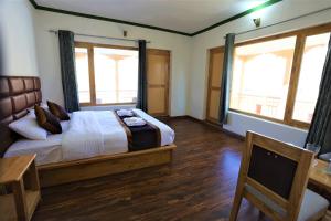 una camera da letto con un letto, una scrivania e due finestre di Paradise Shey a She