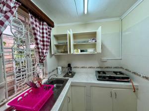a kitchen with a pink sink and a window at Charming Retreat in Garden Estate-Thome, Thika Rd in Nairobi