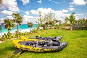 - deux kayaks assis sur l'herbe à côté de la plage dans l'établissement Wild Orchid home, à Governorʼs Harbour