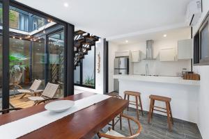 une cuisine et une salle à manger avec une table et des chaises en bois dans l'établissement Stunning 4br - Rooftop Pool, 5 mins to beach, à Tulum