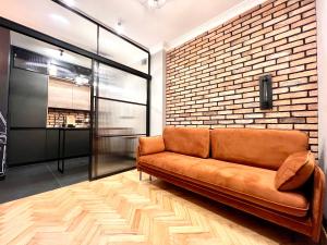 brązowa kanapa w pokoju z ceglaną ścianą w obiekcie AAA STAY Old Town Mariensztat w Warszawie