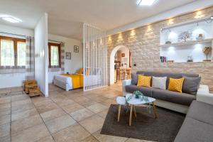 a living room with a couch and a table at Domo Anghèleda - Detached with large garden in a relaxing environment, a few minutes from the sea in Alghero
