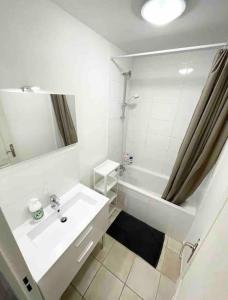 a white bathroom with a sink and a shower at Très spacieux et lumineux appart. Calme&agréable in Vaulx-en-Velin