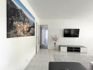 a living room with a tv on a wall at Très spacieux et lumineux appart. Calme&agréable in Vaulx-en-Velin