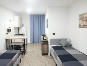 una camera d'albergo con due letti e una cucina di Bed Napoli a Napoli