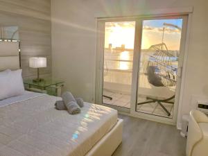 sypialnia z łóżkiem oraz balkon z huśtawką w obiekcie Panoramic luxurious waterfront one bedroom apartment with Miami skyline view Free parking 5min drive to Miami Beach w Miami Beach